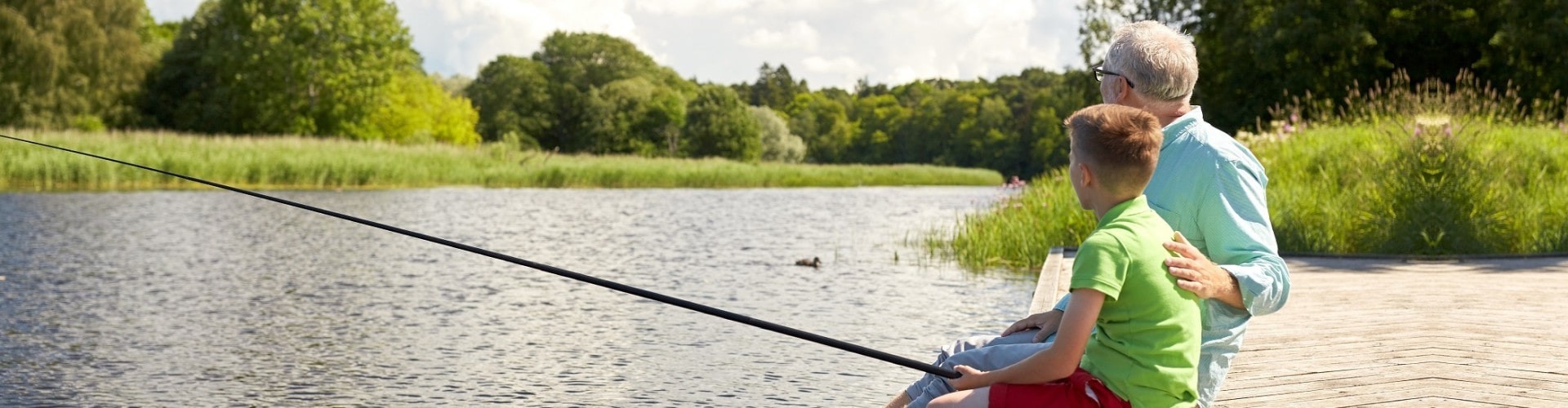 grandpa and grandson fishing at a lake